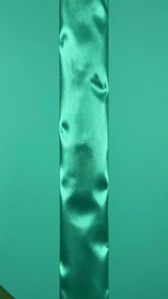 Single orchid column detail, satin texture, teal-green background