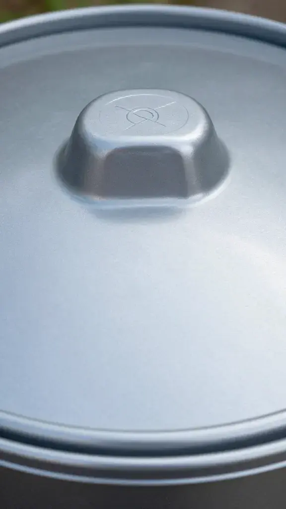 Closeup of a shiny tumbling compost bin lid with engraved logo